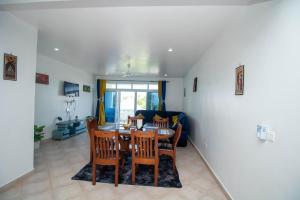 a dining room and living room with a table and chairs at Kijani Suites in Malindi