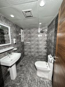 a bathroom with a toilet and a sink at Hotel Sand View in Bawshar