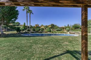 een zwembad in een tuin met palmbomen bij Villa Valerie in Navata