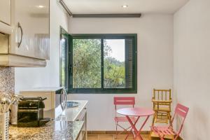 een keuken met een tafel en stoelen en een raam bij Villa Valerie in Navata