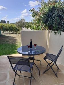 a table with two glasses of wine and two chairs at La Retraite Parfaite in Loubès-Bernac