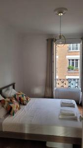 1 dormitorio con 1 cama grande y ventana en Appartement JO proche Paris,CDG,Expo, Stade de France, en Aulnay-sous-Bois
