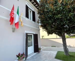 um edifício com duas bandeiras ao lado em FOUR LIONS VILLA GUESTHOUSE em Pisa