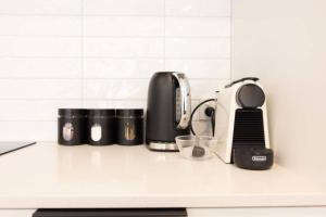 a kitchen counter with a coffee maker and a toaster at Inner City Luxury With Free Parking in Christchurch