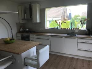 cocina con armarios blancos, fregadero y ventana en Doppelzimmer im Urlaubsparadies nur 20 Minuten von Köln! en Overath