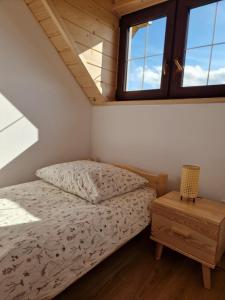 a bedroom in a tiny house with a bed and a table at Dziewięćsił &Chaber _domki blisko lasu in Grywałd