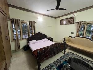 ein Schlafzimmer mit einem Bett und einer Badewanne in einem Zimmer in der Unterkunft SAN HOME STAY in Mysore