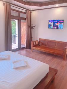 una camera con un letto e una panca di QUEEN'S HOUSE a Luang Prabang