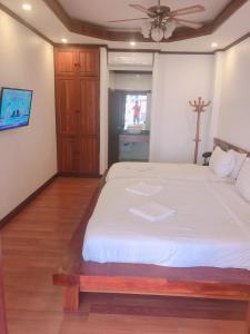 a bedroom with a large white bed with a ceiling at QUEEN'S HOUSE in Luang Prabang