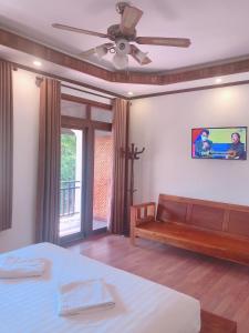 a bedroom with a bed and a tv on the wall at QUEEN'S HOUSE in Luang Prabang