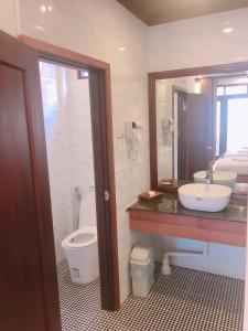 a bathroom with a toilet and a sink and a mirror at QUEEN'S HOUSE in Luang Prabang