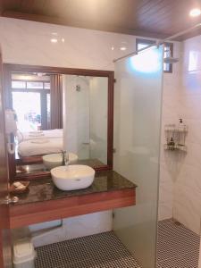 bagno con lavandino e specchio di QUEEN'S HOUSE a Luang Prabang