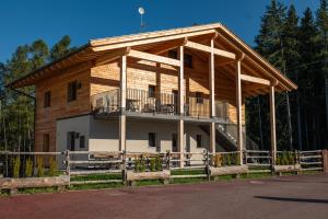 - un grand bâtiment en bois avec une terrasse couverte et un balcon dans l'établissement Ferienwohnung Mittager Edelweiss, à Avelengo