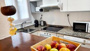 a box of apples on a counter in a kitchen at La Casita Denia, charming 2BR Townhouse with shared Pool, 1km to Beach in Els Poblets