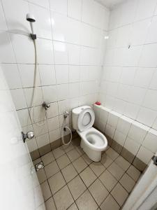 La petite salle de bains est pourvue d'une douche et de toilettes. dans l'établissement Bassura Apartment by Aok Property, à Jakarta