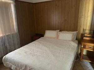 1 dormitorio con 1 cama con sábanas blancas y ventana en Blue Sapphire Village 3 Bedroom, en Glen Innes