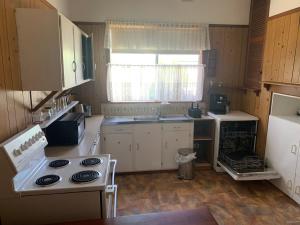 una piccola cucina con piano cottura e lavandino di Blue Sapphire Village 3 Bedroom a Glen Innes