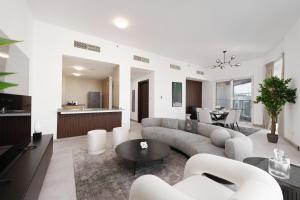 Maison Privee - Elegant & Panoramic Sea View Apt on Al Reem Island في أبوظبي: غرفة معيشة مع أريكة وطاولة