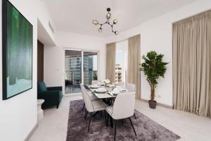 Maison Privee - Elegant & Panoramic Sea View Apt on Al Reem Island في أبوظبي: غرفة طعام مع طاولة وكراسي بيضاء