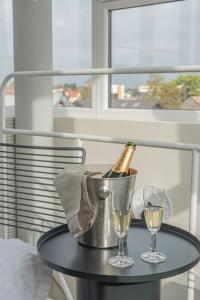 a bottle of champagne in a bucket and two glasses on a table at SPA apartamentai Palanga in Palanga