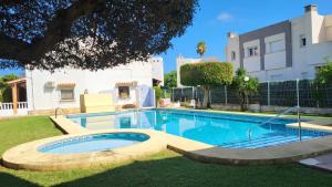 a swimming pool in a yard next to a building at La Casita Denia, charming 2BR Townhouse with shared Pool, 1km to Beach in Els Poblets