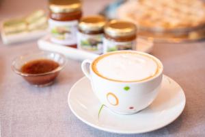 a cup of coffee on a plate on a table at Agriturismo da Natalino in Ceggia +48 photos