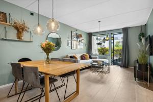 uma sala de estar com uma mesa e um sofá em Nydelig leilighet med privat terrasse mot bakgård em Oslo