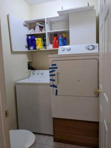 a small bathroom with a washing machine and a toilet at Spacious Bedroom for 4 in shared Townhouse+garden in Brooklyn