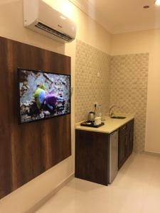 cocina con fregadero y TV en la pared en Golden Square, en Khamis Mushayt