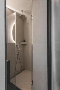 W łazience znajduje się prysznic ze szklanymi drzwiami. w obiekcie SPA apartamentai Palanga w Połądze