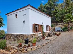 a small white house with a stone wall at Casa Regina in Icod de los Vinos