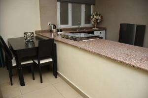 a kitchen with a counter with a table and a sink at Lijam Apartments in Amman