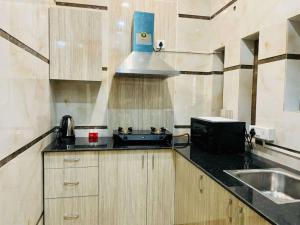 uma pequena cozinha com um lavatório e um fogão em BluO 1BHK - DLF CyberCity, Balcony, Lift, Parking em Gurgaon