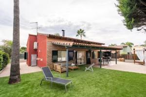 a house with a yard with chairs and a house at Holiday Home Valencia in Riba-Roja De Turia