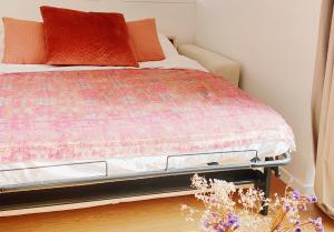 a bed with a colorful blanket on it in a room at Le Bohème ⸱ Stationnement gratuit ⸱ Fibre in Déols