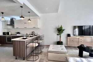 a kitchen with a bar with stools and a tv at Dream Appartment in La Marsa