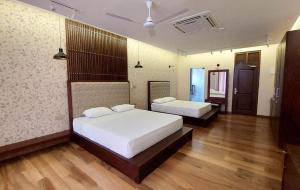 een slaapkamer met 2 bedden en houten vloeren bij Dutch Gate in Aluthgama