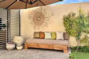 a bench sitting on a patio under an umbrella at Dream Appartment in La Marsa