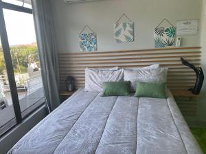 1 dormitorio con 1 cama grande y 2 almohadas verdes en Eagle Wings Accomodation, en Margate