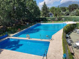 a large swimming pool with blue water at Chalet de 5 habitaciones en la Sierra de Madrid El Olivo de Miraflores in Miraflores de la Sierra