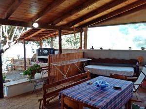 a patio with a table and a couch and a table at apartment over the sea Private place to swim in Ravdhoúkha