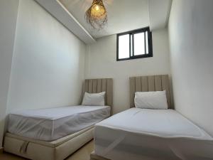 una camera da letto con due letti e una finestra di La Brise Studio à Taghazout 2-3px a Taghazout