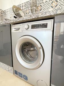 een wasmachine onder een aanrecht bij La Brise Studio à Taghazout 2-3px in Taghazout