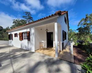 a small white house with a porch at Chalé - Casa do Rosal in Ribeira Funda