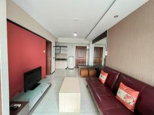 a living room with a couch and a flat screen tv at Galeri Ciumbuleuit Apartment 1 2BR 1BA - code 26A in Bandung
