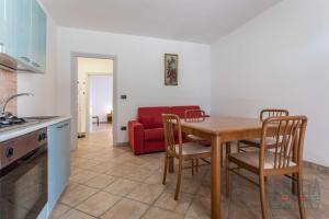 een keuken en eetkamer met een tafel en een rode bank bij Bilocale Afrodite a Torre Vado in Torre Vado