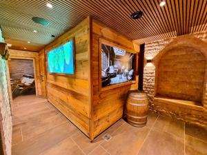 a room with a wooden wall with a barrel and a tv at Best Western Plus BierKulturHotel Schwanen in Ehingen