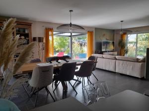 a living room with a table and chairs and a couch at La Zénitude chambre d hôte in Chamarandes