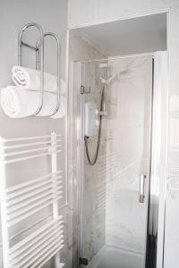 a bathroom with a shower with towels and a glass shower stall at Home Away From Home in Sheffield