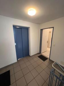 Zimmer mit blauer Tür und Fliesenboden in der Unterkunft Centered Apartment with view in Altdorf